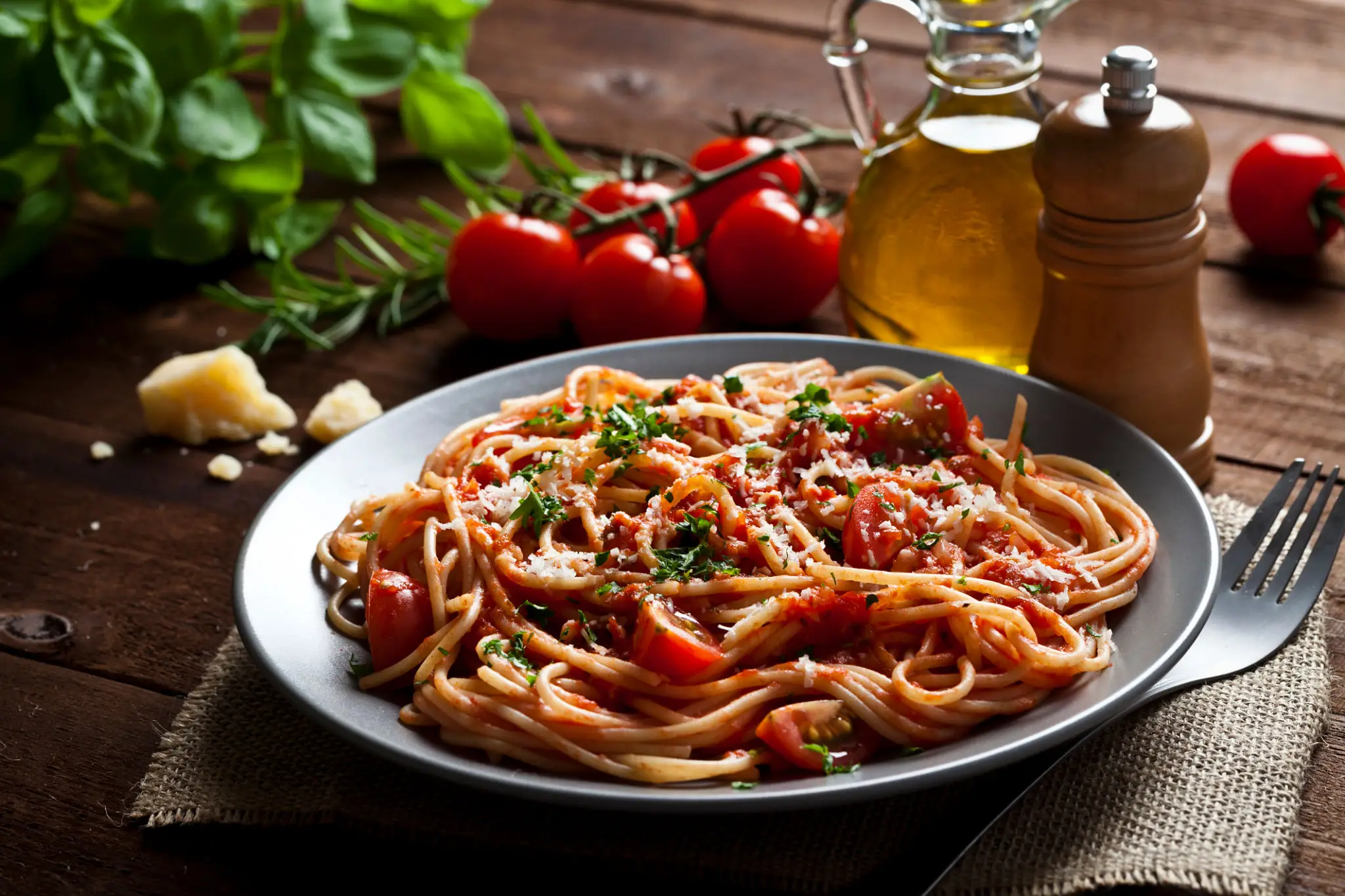 A plate of spaghetti with tomato sauce and herbs.