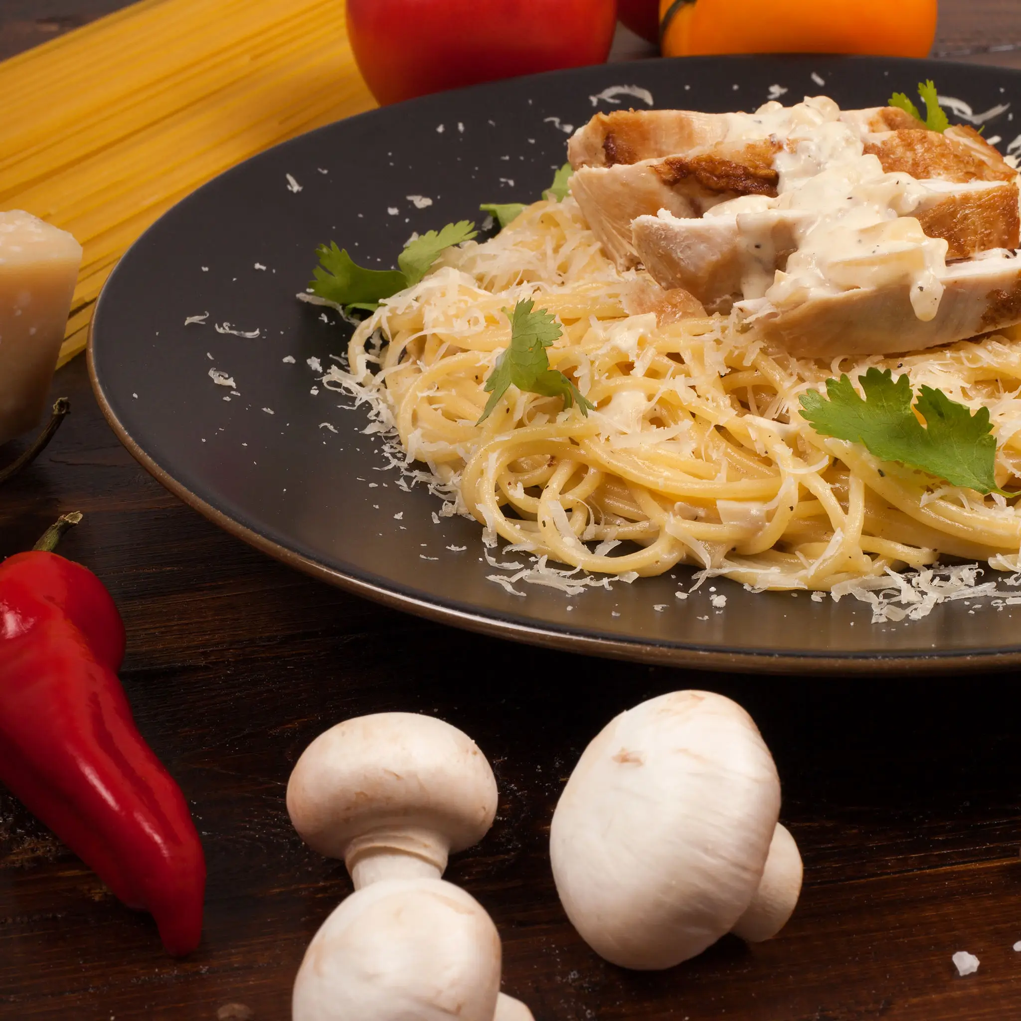 Plate of spaghetti topped with grated cheese and herbs.